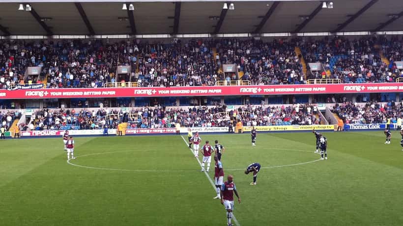 Millwall en West Ham supporters op het veld voor de derby te Londen