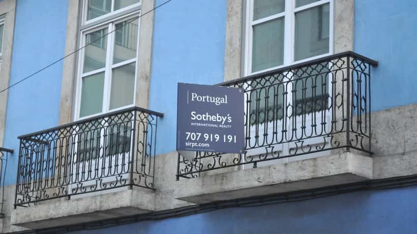 Rua de Lisboa com varandas típicas de edifícios residenciais portugueses