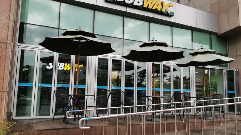 Intérieur d'un restaurant Subway avec comptoir de service et menu visible