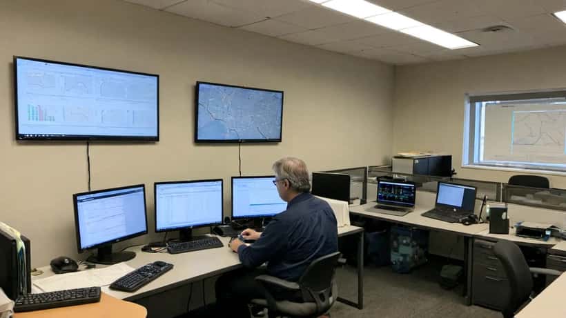 IT consultant reviewing cloud infrastructure and AI workload dashboards in an office