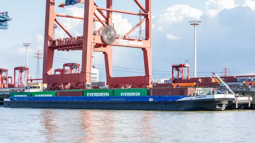 Navio cargueiro em terminal de contêineres representando o comércio internacional