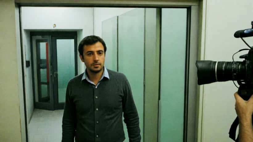 Apresentador de televisão em corredor de estúdio televisivo em Lisboa após rescisão de contrato