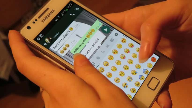 Henkilö kirjoittaa viestejä WhatsApp-sovelluksessa älypuhelimella