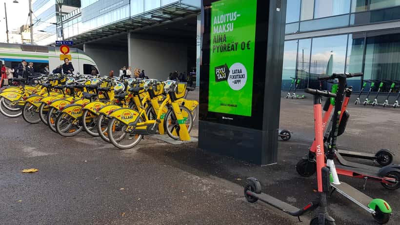 Elsparkcyklar och stadscyklar uppställda vid Helsingfors centralstation, ett vanligt stadsbild i Norden