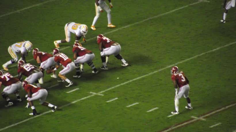 Alabama Crimson Tide quarterback dropping back for a pass on the football field