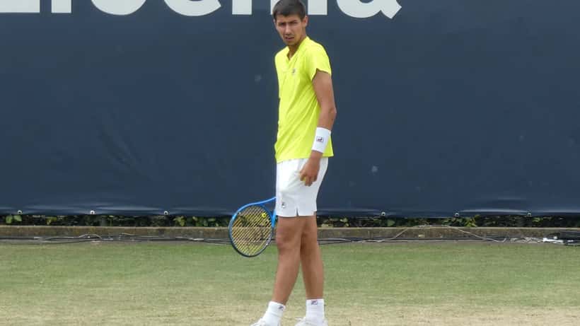 Alexei Popyrin playing tennis on court at Rosmalen, mid-match action shot