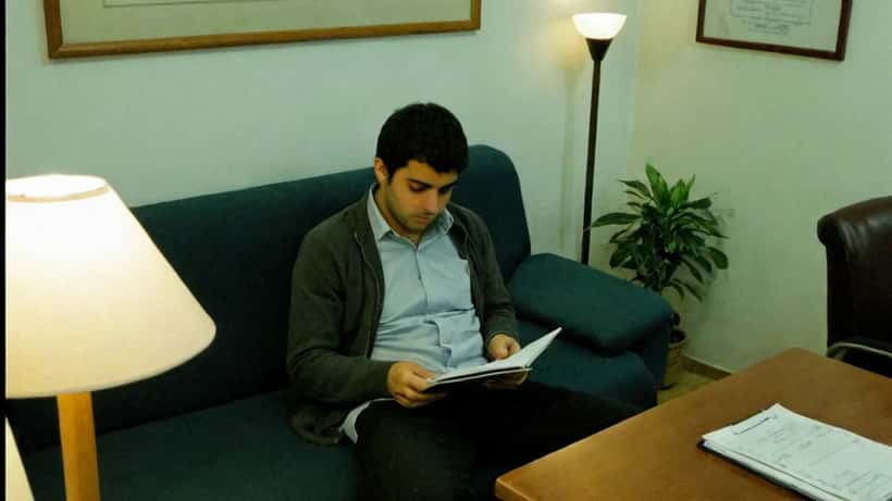 Jovem adulto em consulta de psicologia num gabinete de Lisboa, reflexão sobre dependências e saúde mental