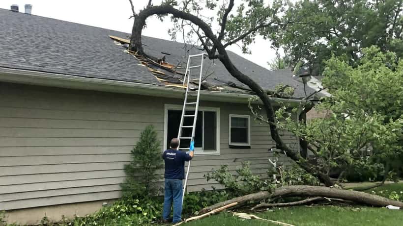 Homeowner inspecting tornado roof damage in the Midwest after spring 2026 storms