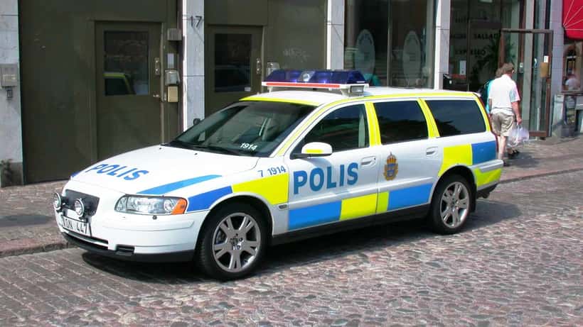 Svensk polisbil med ny blå-gul dekal parkerad utanför – illustration av polisinsats i Ludvika