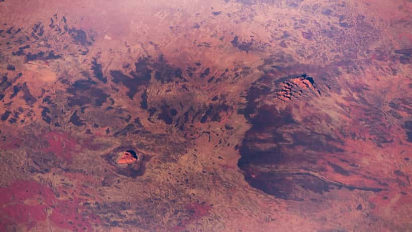 Vast Australian outback landscape with red earth and sparse vegetation under a wide open sky