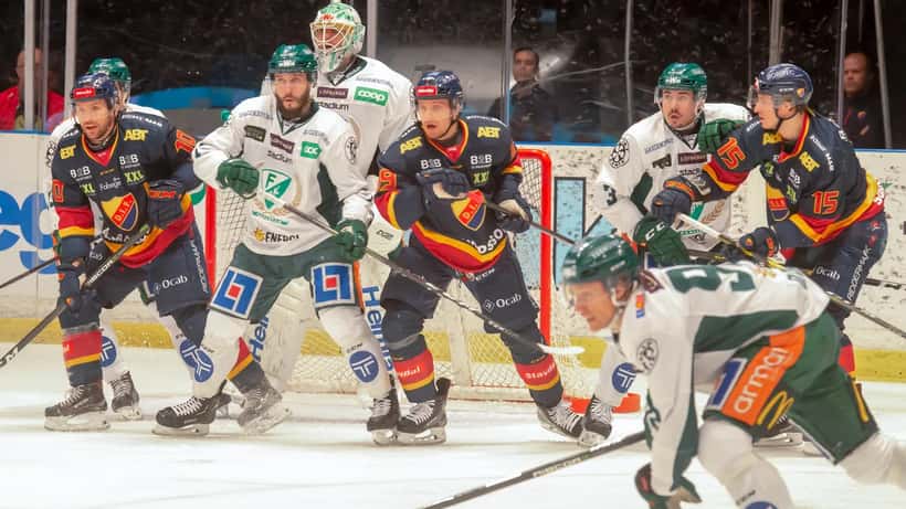SHL-ishockeymatch på isen — spelare i kamp om pucken under svensk elitishockey
