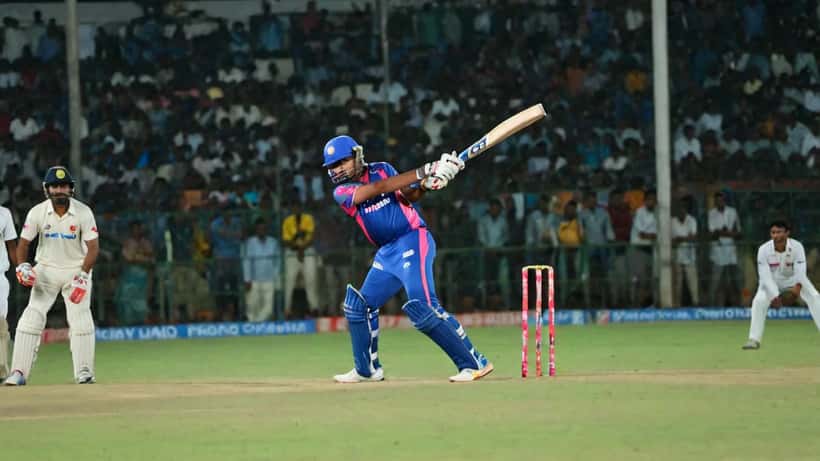 Young cricketer in batting stance at an IPL stadium under floodlights