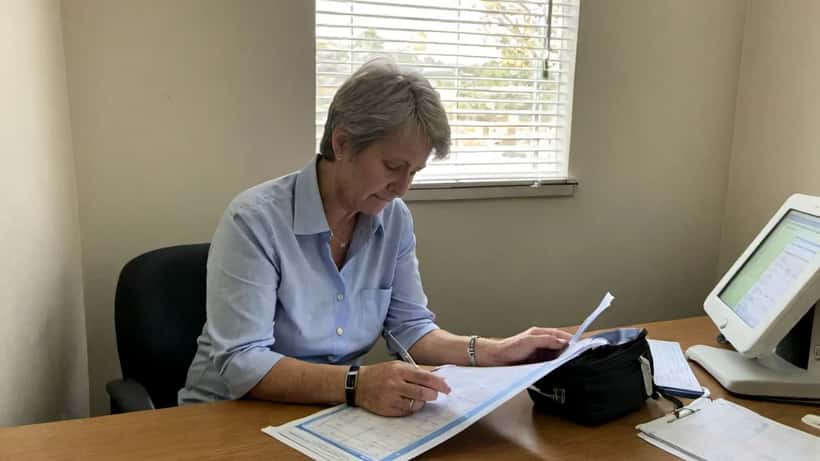Australian woman in her 50s reviewing health screening results with her GP in a modern consultation room