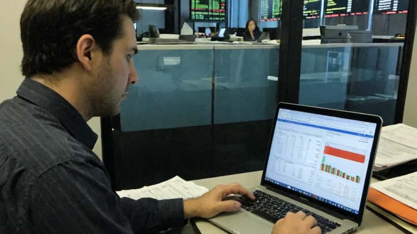 Conseiller financier canadien analysant l'impact des tarifs douaniers américains sur un portefeuille d'investissement