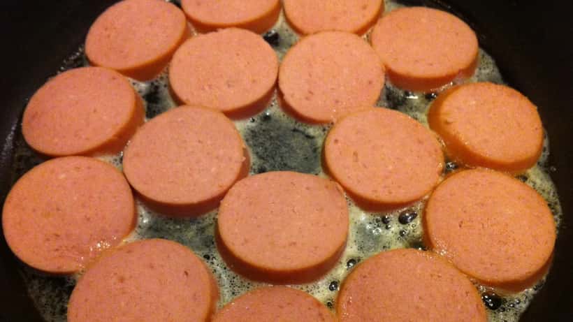 Falukorv, traditionell svensk korvprodukt, liggande på träunderlag