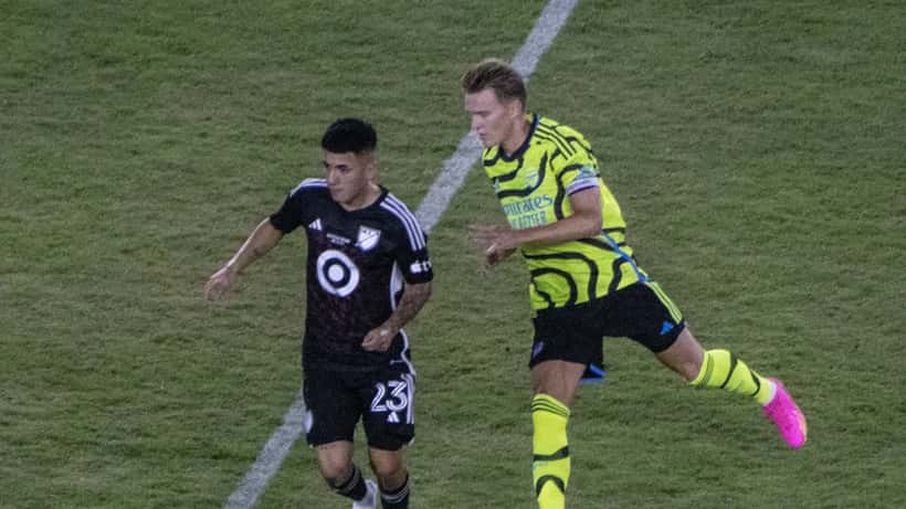Martin Ødegaard og medspiller under fotballkamp, representerer prestasjonspress i toppidrett