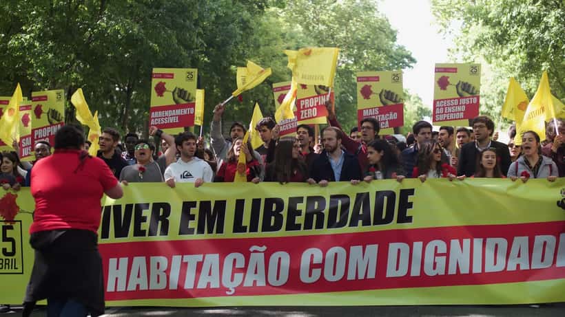 Jovens membros do Partido Socialista celebram o aniversário da Revolução dos Cravos em Lisboa com cravos vermelhos