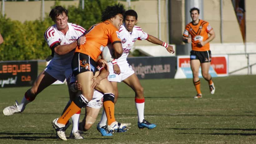Rugby league players in a tackle during an NRL match