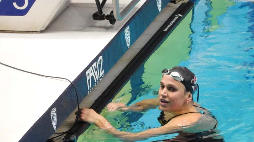 Swimmer in a championship pool post-race, illustrating elite training demands and injury risk