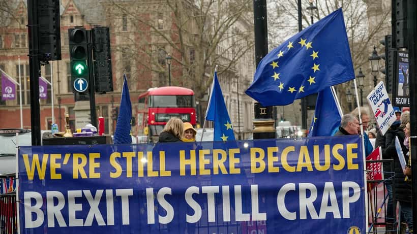Protesters gathered in Parliament Square, London, holding signs during a demonstration