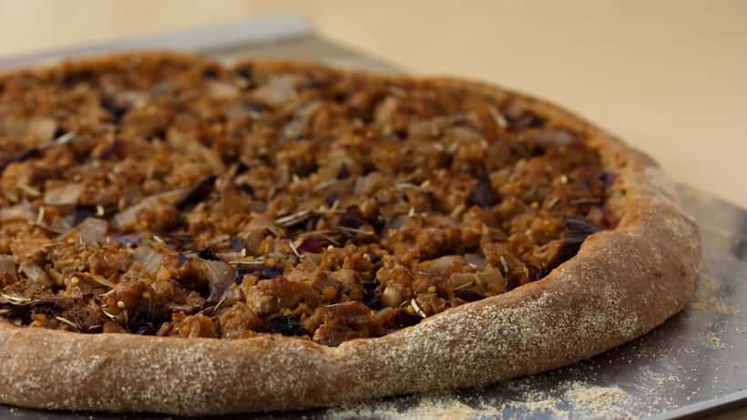 Freshly made sourdough pizza crust on wooden surface representing London's artisan pizza scene in 2026