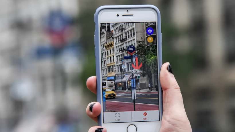 Eine sehbehinderte Person nutzt eine Smartphone-App mit Assistenzfunktionen im öffentlichen Nahverkehr