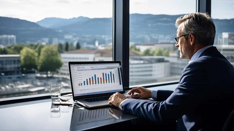 Conseiller financier analysant un tableau de bord de score de crédit sur ordinateur dans une banque suisse