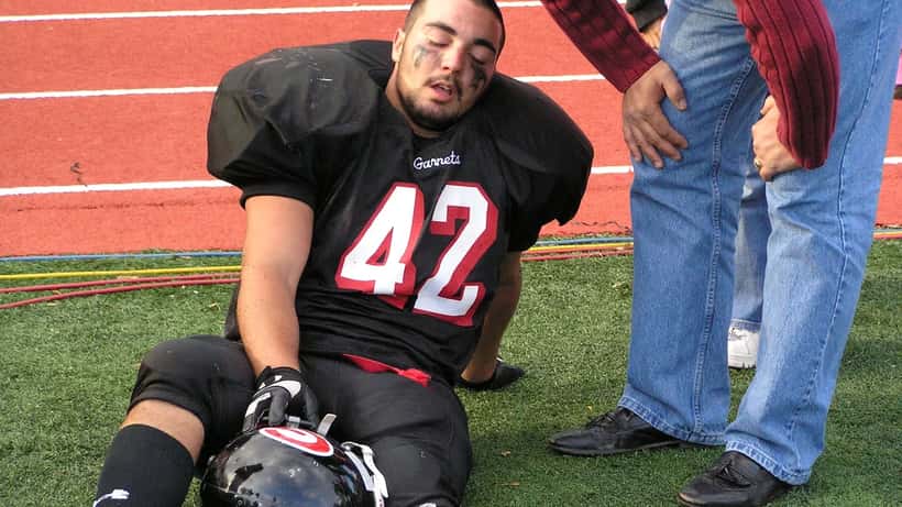 Joueur de football amateur blessé au sol sur le terrain, soins médicaux pendant un match