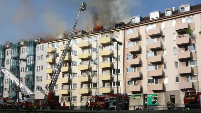 Feuerwehr löscht einen Wohnungsbrand in einem Mehrfamilienhaus