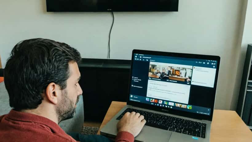 Homme regardant un service de streaming sur son ordinateur portable dans un salon moderne en Suisse