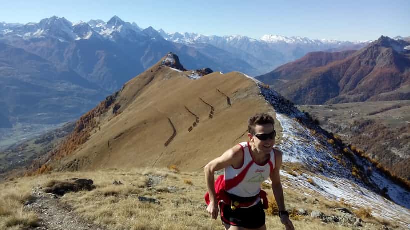 Atleta di trail running su sentiero di montagna nelle Prealpi italiane