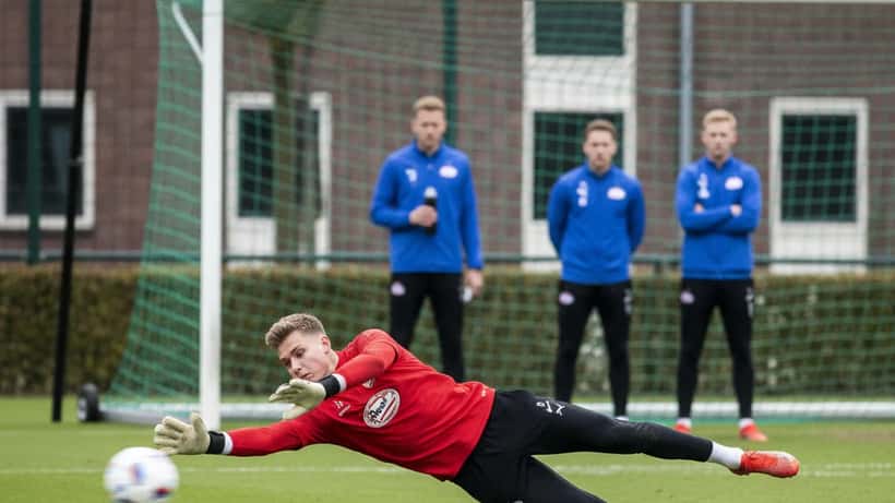 Jonge professionele keeper duikt naar bal op trainingscomplex in Eindhoven