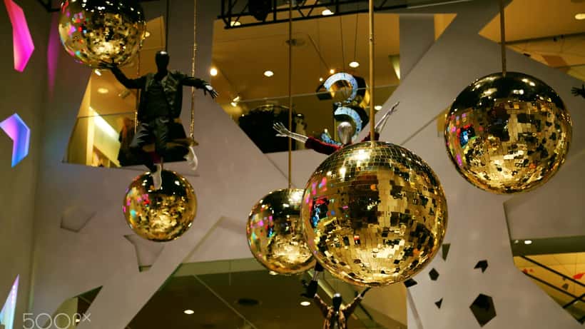 H&M butik interiör med klädgalgar och monter, anställda i bakgrunden