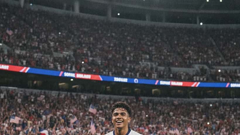 American soccer player in USMNT kit celebrating a goal at SoFi Stadium, World Cup 2026