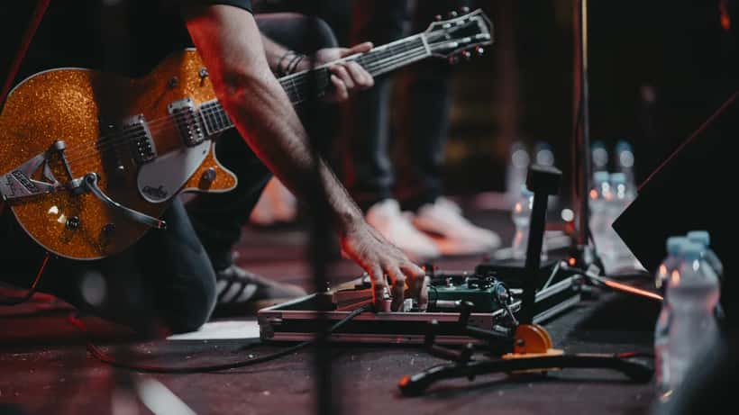 Músico a tocar guitarra elétrica em concerto ao vivo