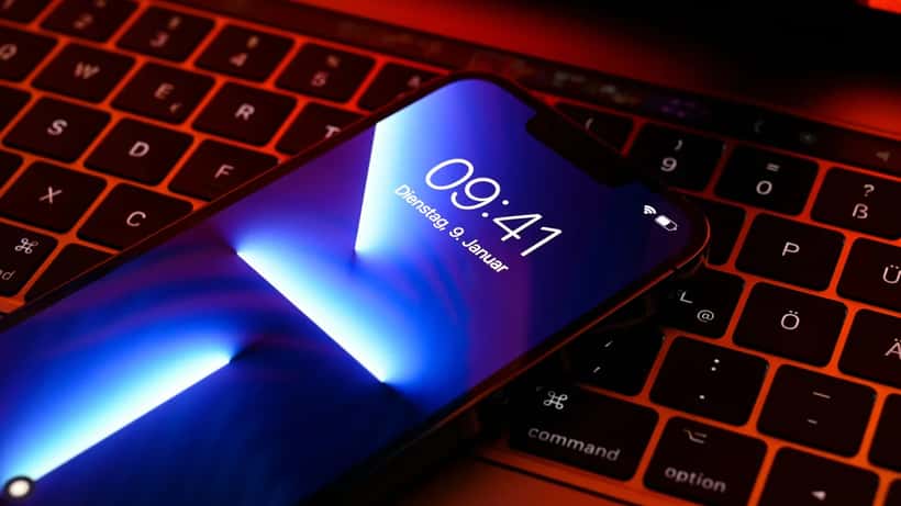iPhone Pro Apple posé sur un MacBook Pro, illustration de la sécurité des données mobiles