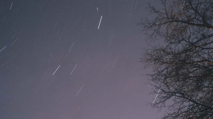 Long-exposure photograph of Lyrid meteors streaking across a dark night sky