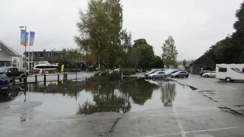 Flooded car park in the UK with cars surrounded by standing water after heavy rain warning