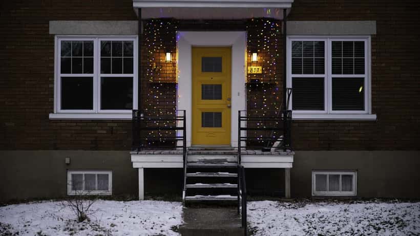 Quebec City street lined with snow-covered homes after a spring snowstorm, showing heavy accumulation on roofs