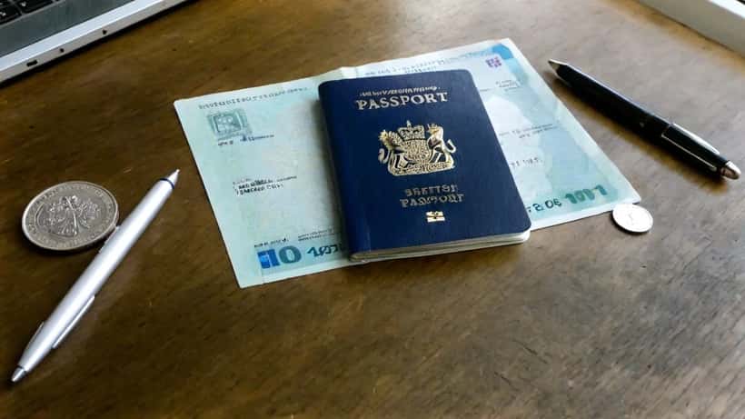 British passport and documents on a desk with sterling coins