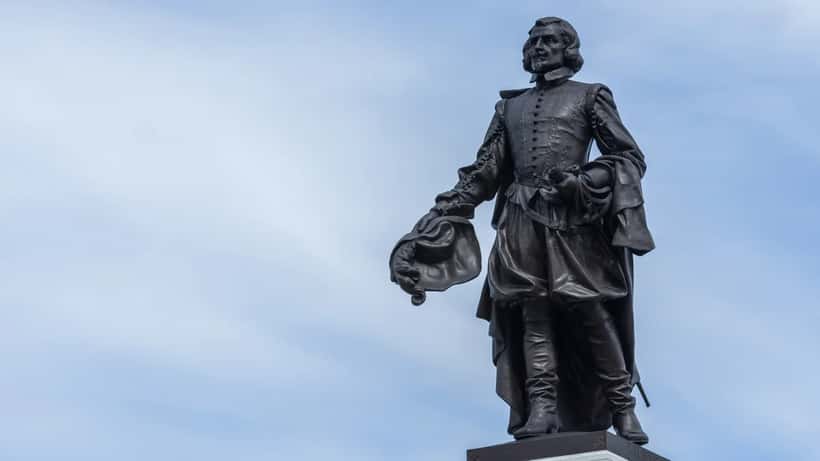 Samuel de Champlain bronze monument standing tall against a clear sky in Canada