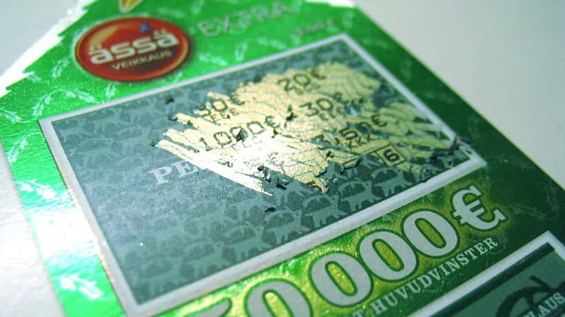 Lottery scratch card with revealed numbers, coin used to scratch the surface