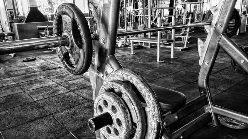 A person performing a bench press exercise in a gym during a personal training session