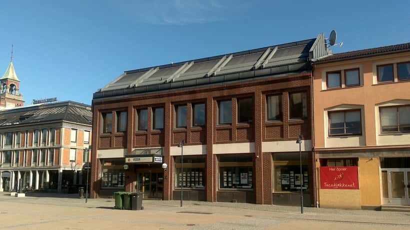 Fasade på en tradisjonell norsk sparebank med stort vindu og inngangsparti