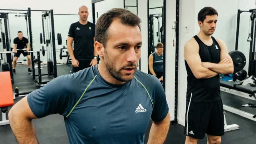 Homme athlétique en séance d'entraînement intensif avec coach dans un studio sportif à Zurich, Suisse