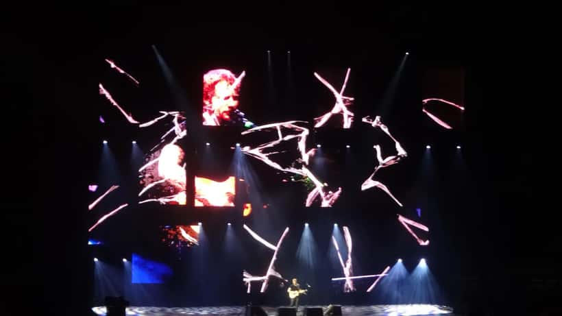 Ed Sheeran en concierto con guitarra en estadio lleno de fans