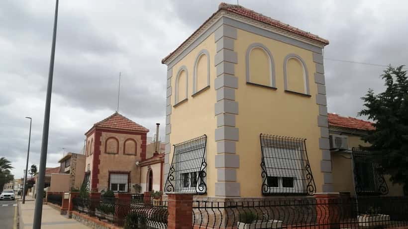 Moradias de luxo frente ao passeio marítimo em Alicante, Espanha, com palmeiras e mar Mediterrâneo ao fundo