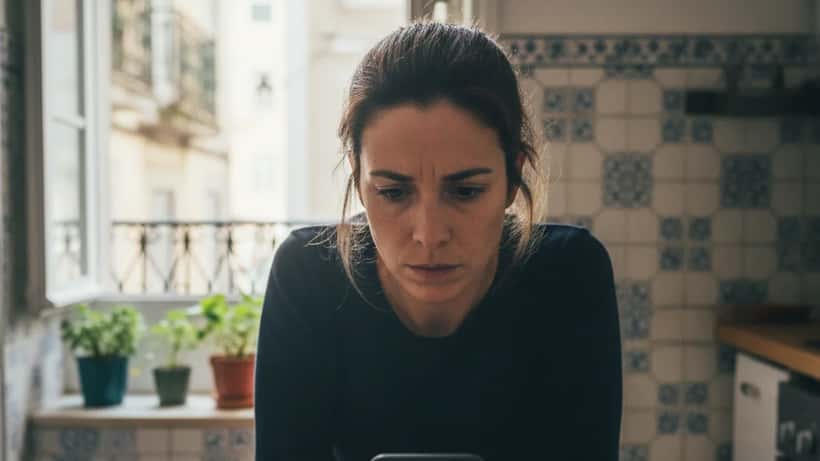 Mulher portuguesa preocupada a olhar para o telemóvel com notificação MBWay suspeita