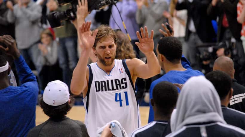 Dirk Nowitzki high-fiving fans during a 2013 NBA game
