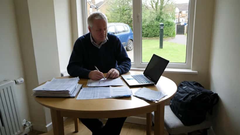 Person reviewing HMRC tax documents at home with laptop